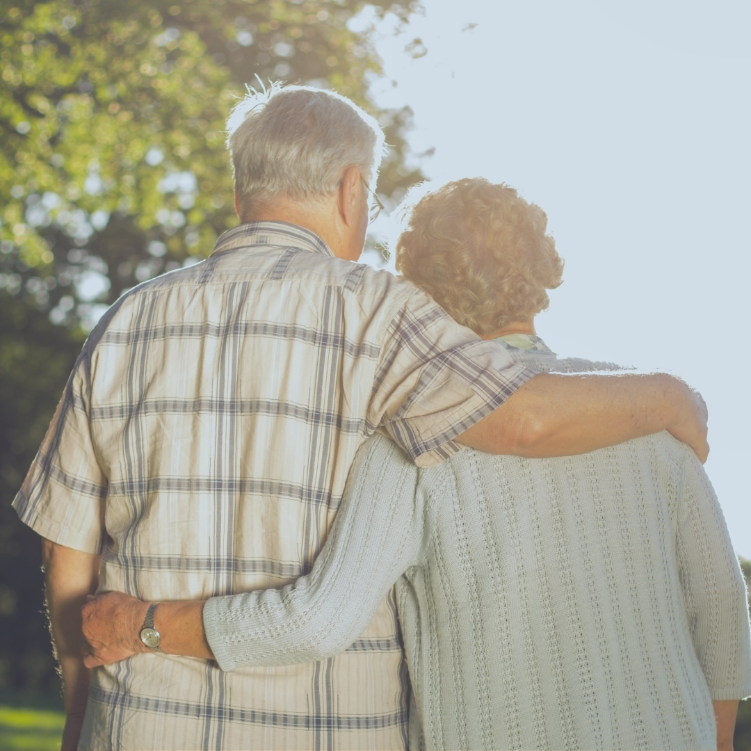 An elderly couple hugging eachother