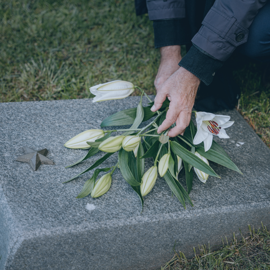Someone placing flowers on a grave